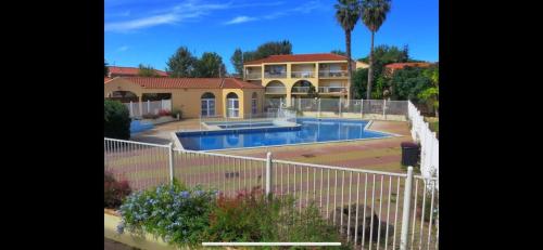 une maison avec une piscine dans une cour dans l'établissement Le Cosy Canétois - A 20 min de la plage, à Canet