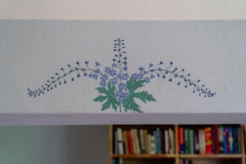 a painting of a flower on the top of a book shelf at Ielejas A place for cool living in Vircava