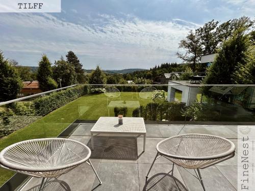 a patio with two chairs and a table on a balcony at Résidence de 3 appartements luxueux - 2 ch x 3 - "Tilff Le Mont" by FineNest in Tilff