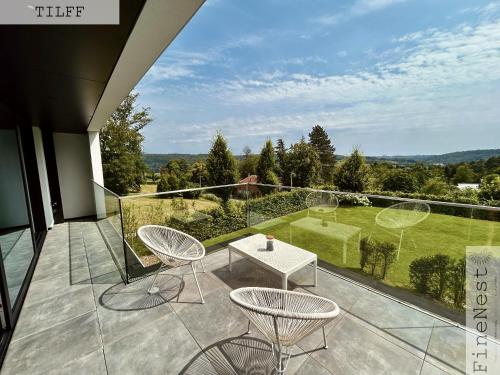 a patio with chairs and a table on a balcony at Résidence de 3 appartements luxueux - 2 ch x 3 - "Tilff Le Mont" by FineNest in Tilff
