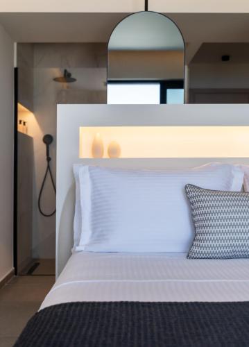 a bedroom with a white bed with a mirror above it at NimVie Green Retreat in Skiathos Town