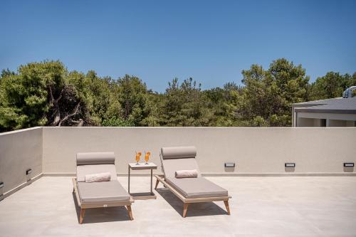 two chairs and a table on a patio at Inea Sole Boutique Hotel in Kato Daratso