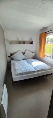 メッペンにあるKNAUS Campingpark Meppenの窓のある部屋にある白いベッド
