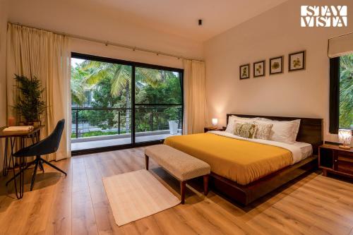 a bedroom with a bed and a large window at StayVista at M Villa with Breakfast Included in Bengaluru