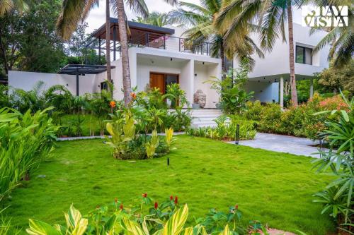 a house with a lawn in front of it at StayVista at M Villa with Breakfast Included in Bengaluru