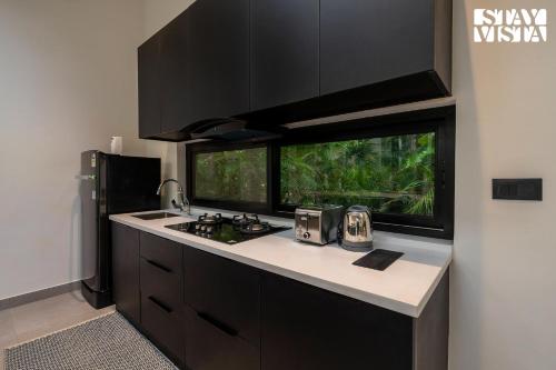 a kitchen with a counter with a sink and a window at StayVista at M Villa with Breakfast Included in Bengaluru