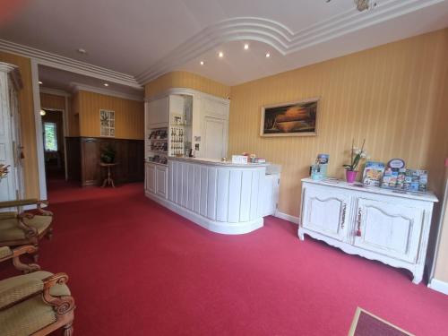 a large room with a red carpeted room with aasteryasteryasteryasteryastery at La Villa Bois Joli HOTEL RESTAURANT in Bagnoles de l'Orne