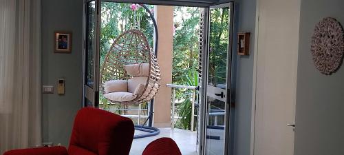 a room with a swinging chair and a glass door at All Seasons Villa 1, Golem Kompleksi Dielli in Qerret