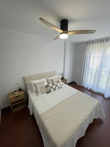 a bedroom with a bed with a ceiling fan at Apartamento Ensenada de Barraña in Boiro