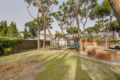 a yard with trees and a fence at Bonito Apartamento En Gava Mar in Gavà