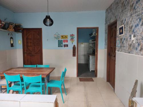 a dining room with a wooden table and blue chairs at Cantinho especial in Recife