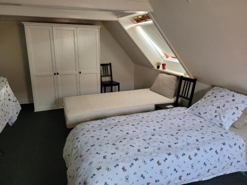 a small bedroom with two beds and a cabinet at Skrædderens Baghus in Assens