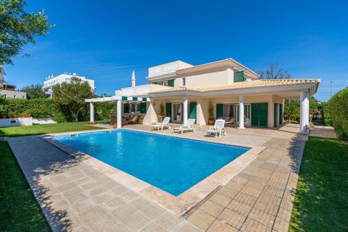 a villa with a swimming pool in front of a house at VILLA DO VALE- Stunning Family Villa with Pool in Tavira