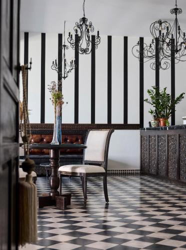 a chair in a room with a black and white floor at La Casa E Il Mare, Private Bay Hotel in Mattinata