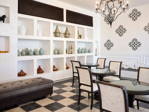 a room with tables and chairs and shelves with vases at La Casa E Il Mare, Private Bay Hotel in Mattinata