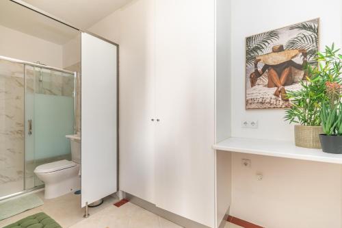 a white bathroom with a toilet and a shower at VILLA DO VALE- Stunning Family Villa with Pool in Tavira