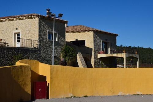 a house with a yellow fence in front of it at Chambres d'hôtes au Mas du Sire in Quissac