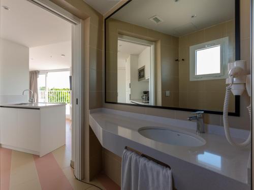 a bathroom with a sink and a large mirror at Apartamentos Sunway Atlanta in Sitges