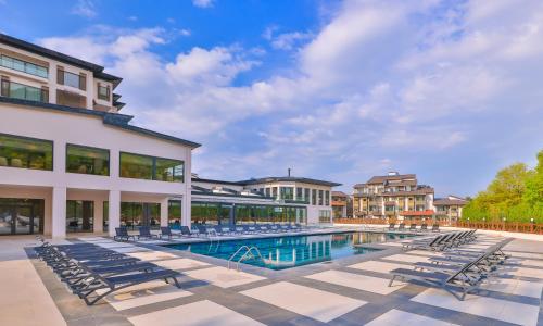 a pool with lounge chairs next to a building at Narven Wellness & Thermal Hotel in Yukarımahalle