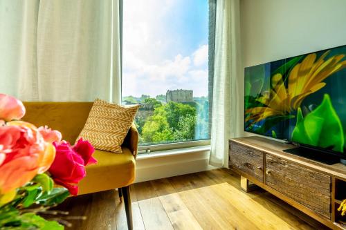 a living room with a couch and a large window at River & Castle at Ryedale House in York
