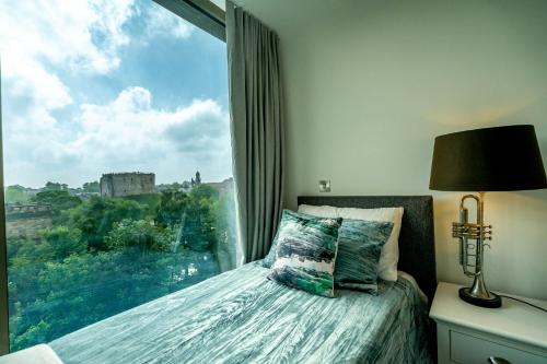 a bedroom with a bed with a large window at River & Castle at Ryedale House in York