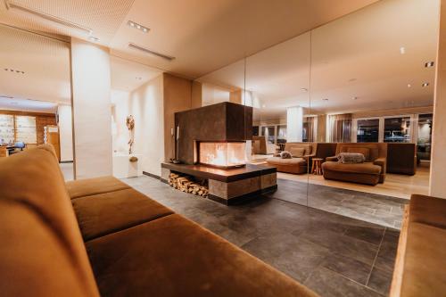 a living room with a couch and a fireplace at Post Seefeld - Wellnesshotel Tirol in Seefeld in Tirol