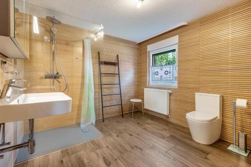 a bathroom with a sink and a toilet and a window at Kleines Glück in Seedorf