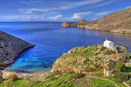 a white chapel on top of a hill next to the ocean at Peter & Tony Rooms in Galissas
