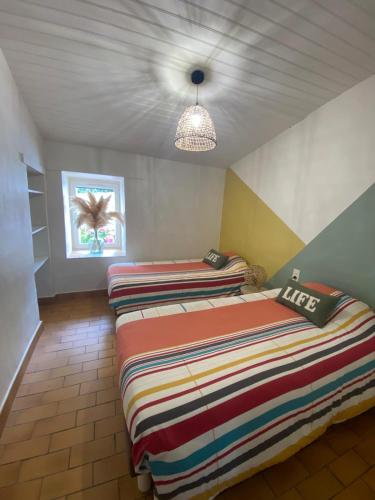 two beds in a room with a ceiling at Les granges du chiron in La Garnache