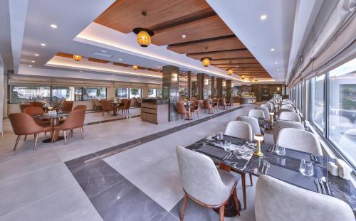 a restaurant with tables and chairs and a bar at Narven Wellness & Thermal Hotel in Yukarımahalle