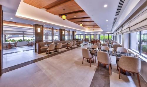 a restaurant with tables and chairs and windows at Narven Wellness & Thermal Hotel in Yukarımahalle