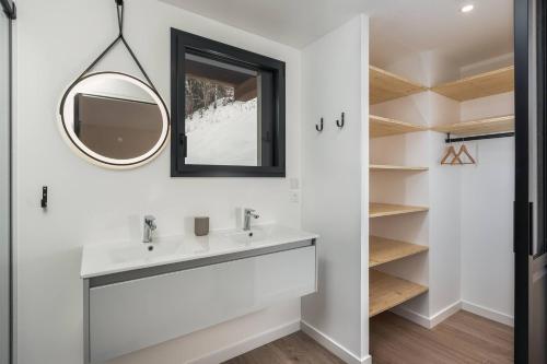 une salle de bain avec un lavabo et un miroir dans l'établissement Les Petits Ours Montriond superbe 8 14 personnes, à Montriond