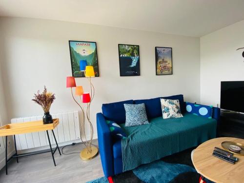 un salon avec un canapé bleu et une table dans l'établissement Casa Mafate, à Angers