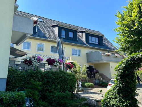 a house with a lot of flowers in front of it at Landhaus Schönfelder Hof in Hollfeld