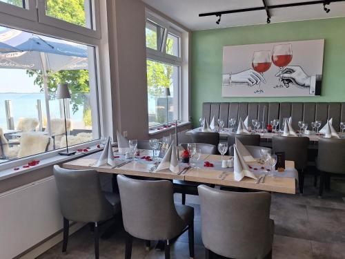 a dining room with a long table with wine glasses at Strandappartements Steinberghaff "Kegnæs" mit Meerblick und Sauna in Steinberg