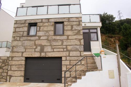 a house with a garage door on the side of it at Casa do Barreiro in Baião