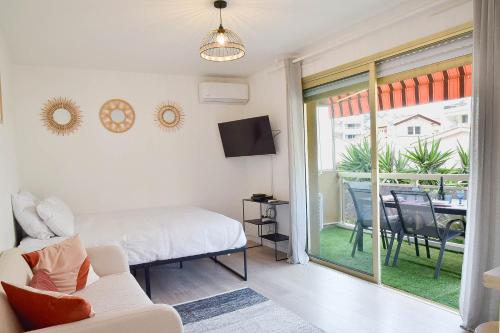 une chambre avec un lit et une porte coulissante en verre dans l'établissement Palm Beach Studio with Terrace 150m from beaches, à Cannes