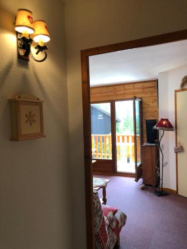 d'un salon avec une porte coulissante s'ouvrant sur une terrasse. dans l'établissement appartement 6 personnes 2 chambres avec Balcon, à Saint-Étienne-en-Dévoluy