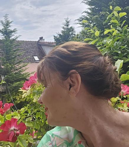 a woman standing in front of some flowers at Park Apartment in Kraków