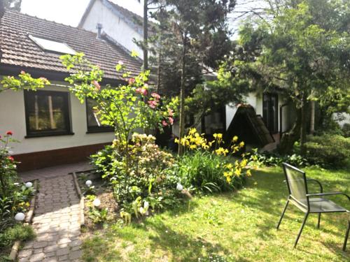 a yard with a chair and flowers in front of a house at Park Apartment in Kraków