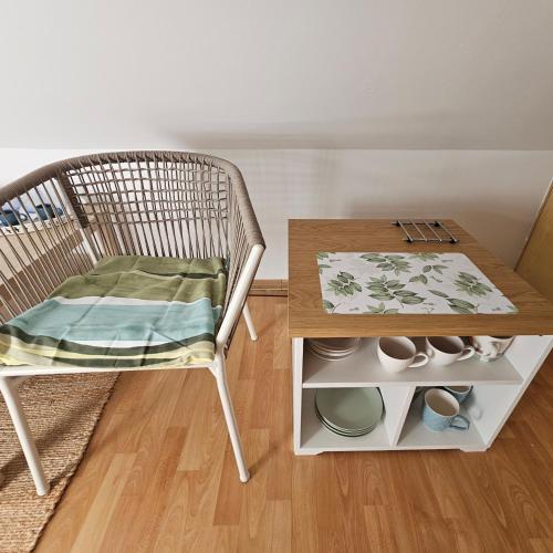 a rattan chair with a table and a wooden table and a table at Park Apartment in Kraków