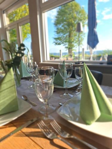 a table with plates and wine glasses on it at Strandappartement Steinberghaff "zur Birk" mit Meerblick in Steinberg