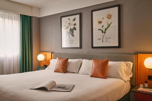 Un dormitorio con una cama con un libro. en Hotel Malcom and Barret, en Valencia