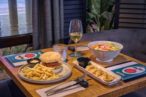 a table with a sandwich and french fries and a glass of wine at Hotel Malcom and Barret in Valencia