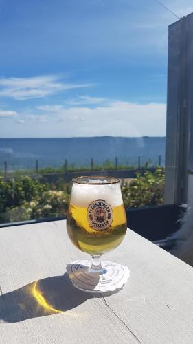 a glass of beer sitting on top of a table at Strandappartement Steinberghaff "zur Birk" mit Meerblick in Steinberg