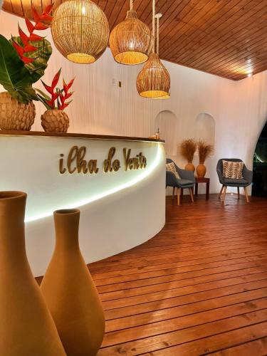 a lobby with vases and potted plants and lights at Pousada Ilha do Vento in São Miguel do Gostoso