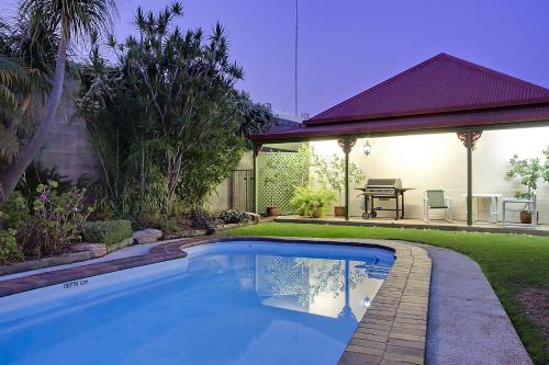 een zwembad in een tuin naast een huis bij Pioneer Motel Goondiwindi in Goondiwindi
