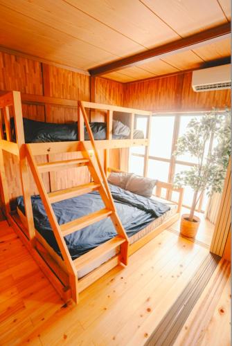 a bedroom with two bunk beds and a window at NorthStar Sea Breeze Holiday Home in Shimoda