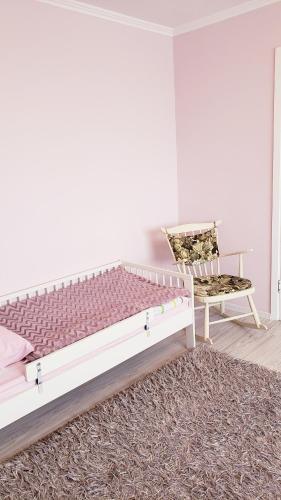 a bedroom with a large bed and a chair at Liudmila in Liepāja