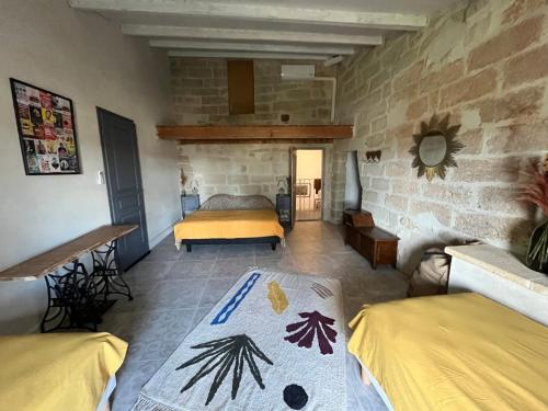 une chambre avec un lit et un mur en pierre dans l'établissement Ancienne Maison de Vigneron avec Jacuzzi - Uzès, à Sanilhac-et-Sagriès